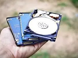 mano sujetando unos discos duros usados en camaras de seguridad con almacenamiento local